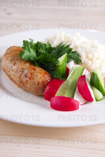 Fried sausage with rice and fresh cucumber and radish