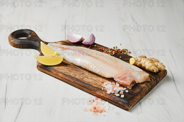 Freshly frozen zander fillet on wooden cutting board