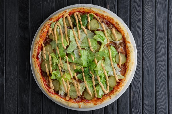 Top view of pizza wth pickled cucumber and salad