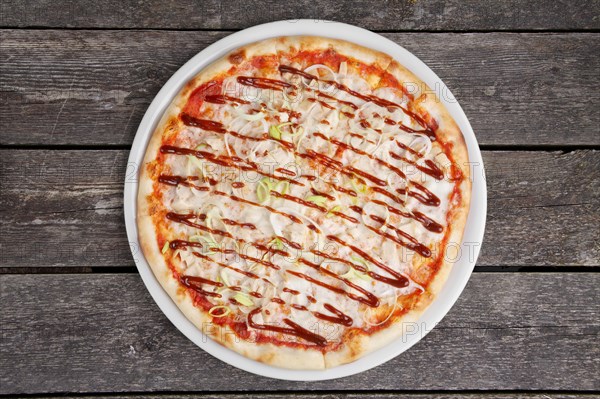 Top view of pizza with chicken barbecue on wooden table