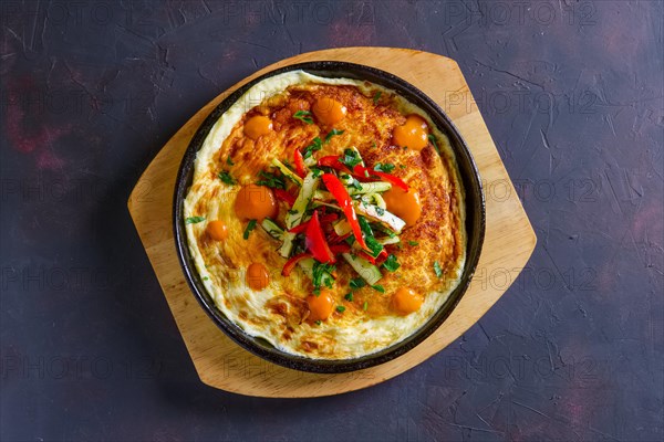 Vegetarian omelette with vegetables in cast iron pan