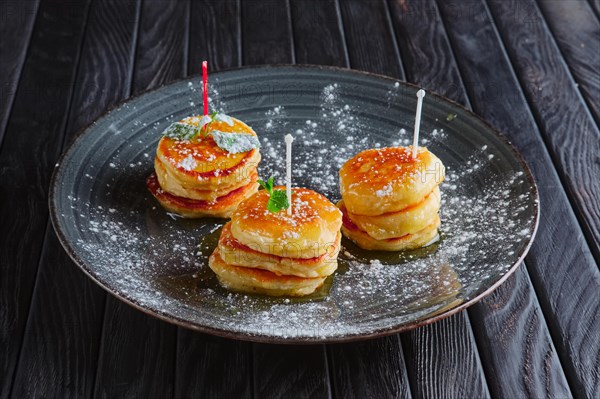 Plate with heap of fritters decorated with honey