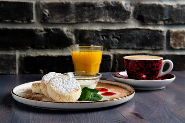 Traditional breakfast with cottage cheese pancake with sour cream