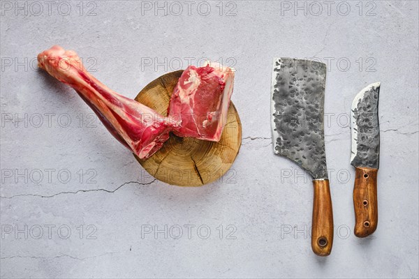 Overhead view of raw fresh deer shank with spice and herb over concrete background