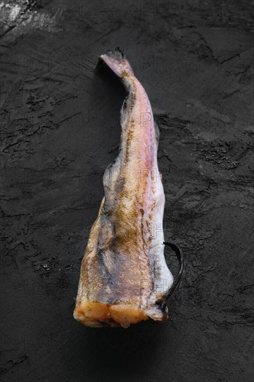 Frozen raw pollock carcass on wooden background