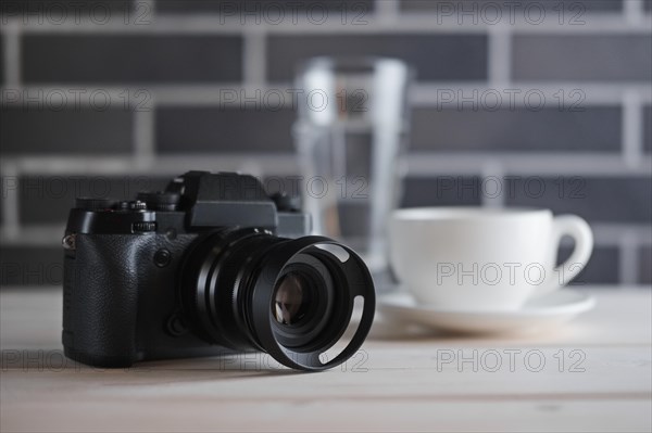 Selective focus lifestyle photo of camera on the table near cup of coffee