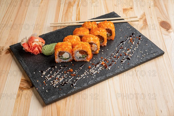 Set of rolls with wasabi and pickled ginger on stone serving board