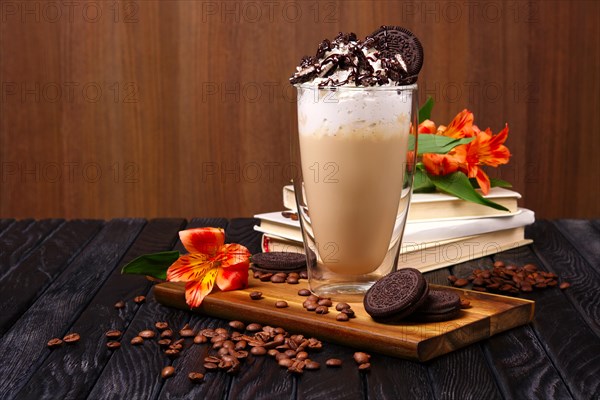 Glass with coffee cocktail with whipped cream and cookie decorated with coffee beans and flowers