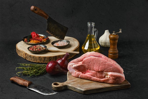 Raw slice of beef steamship round with cooking ingredients on black background