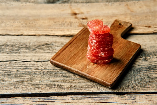 Close up view of smoked dried stacked slices of turkey sausage on wooden cutting board