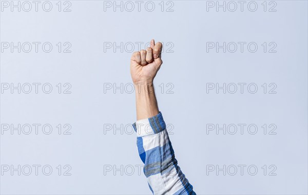 Hand gesturing the letter T in sign language on an isolated background. Man's hand gesturing the letter T of the alphabet isolated. Letter T of the alphabet in sign language
