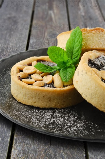 Caramel tart with peanut and mint on a plate