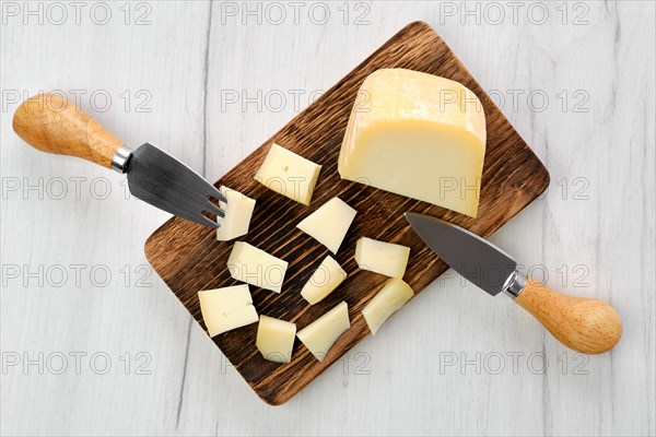 Top view of goat cheese cut on pieces on wooden cutting board