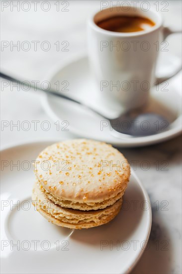 Photo with shallow depth of field of macaron with salted caramel on a white saucer