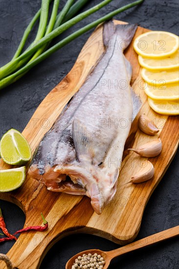 Raw fresh haddock carcass on wooden cutting board