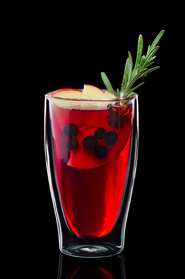 Double-walled glass with hot currant mulled wine isolated on black