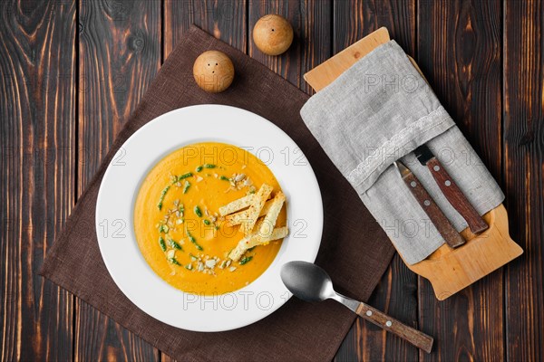 Overhead view of aubergine soup puree with pumpkin seed and crouton