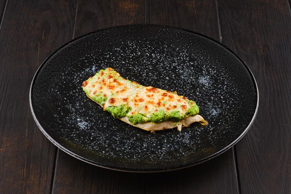 Fried fish fillet with green salsa sauce on a plate