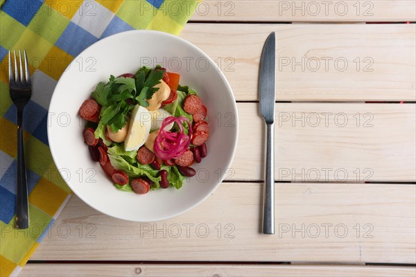 Salad with smoked sausage and egg. Top view of served table