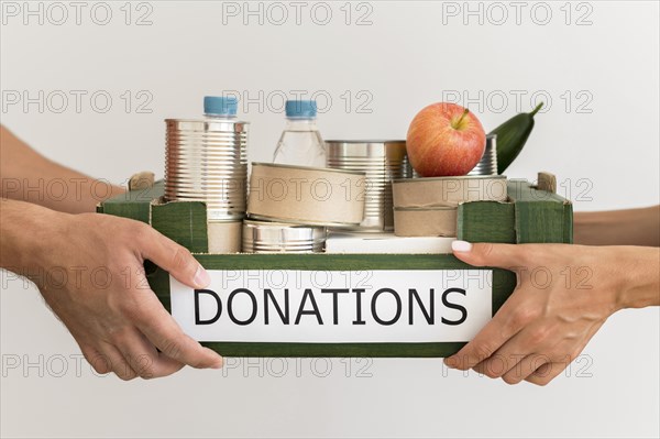 Hands holding donation box with food