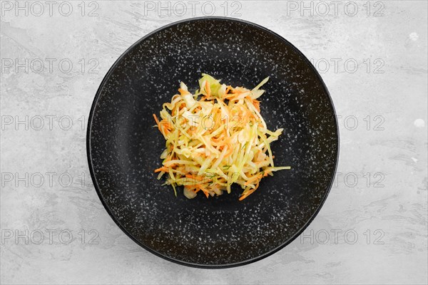 Pickled slices of cabbage and carrot on a plate