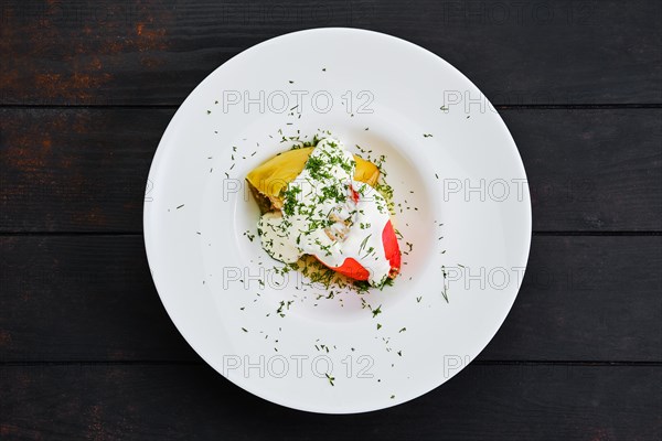 Top view of bell pepper stuffed with minced meat on dark wooden table