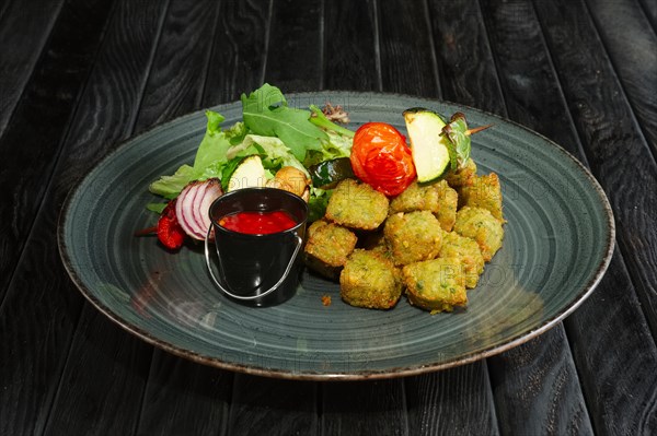 Fried falafel with grilled vegetables on wooden skewer