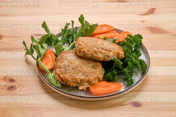 Fried beef cutlet in breading with fresh carrot