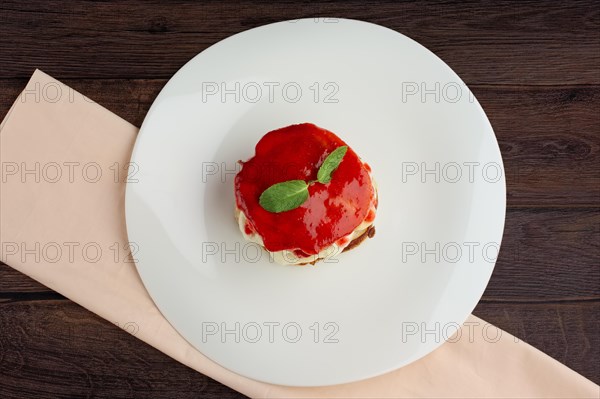 Pile of flapjacks with strawberry jam and banana. Top view on wooden table