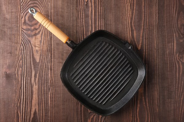 Cast-iron pan top view on wooden background