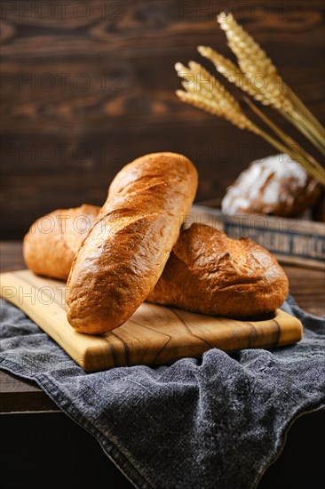 Fresh loaf of wheat bread on wooden cutting board