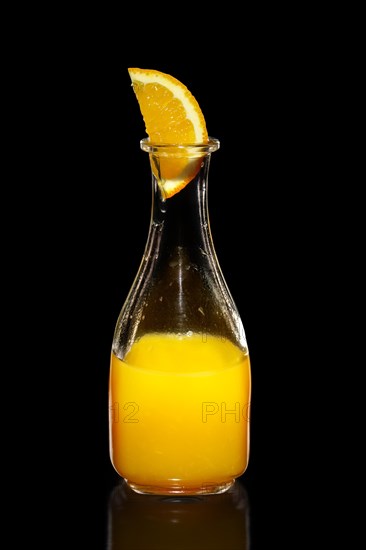 Fresh orange juice as ingredient for vodka cocktail isolated on black