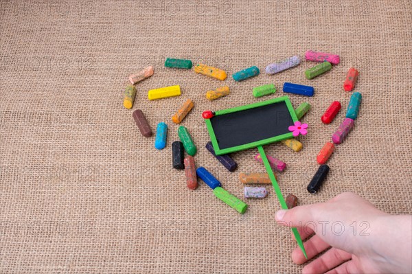 Notice board in the middle of crayons form a heart shape