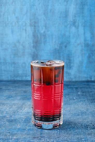 Cold cocktail with beer and black currant