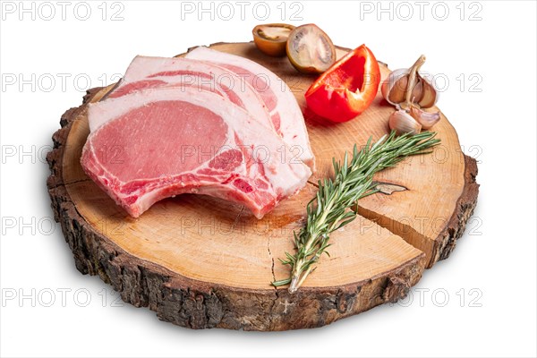 Raw fresh pork fillet steak on the bone on wooden cutting board isolated on white