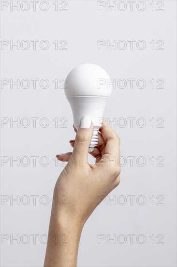 Front view hand holding light bulb with copy space