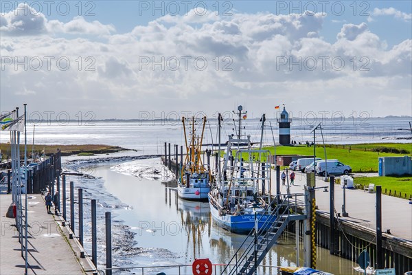 Sielhafen with crab cutters and Kleiner Preusse lighthouse at the mouth of the Weser