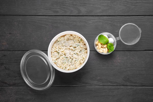 Overhead view of bulgur porridge with almond nuts and hazelnuts and cranberries in sugar pouder breading in take away packaging