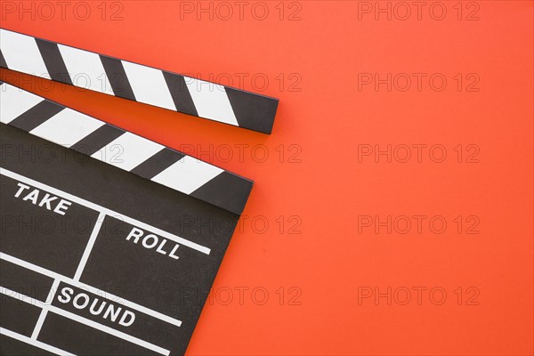 Clapperboard on red background with space