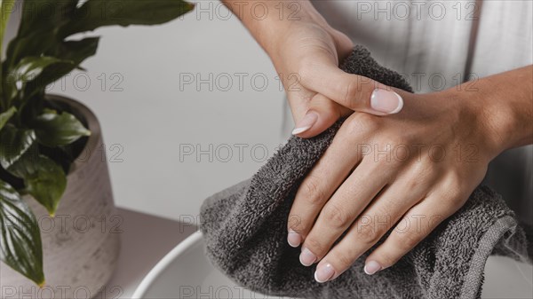 Person drying her hands towel close up
