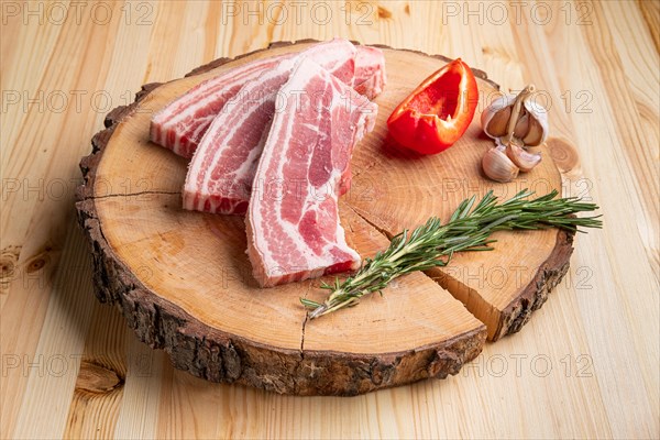 Raw fresh pork brisket slices on wooden cutting board