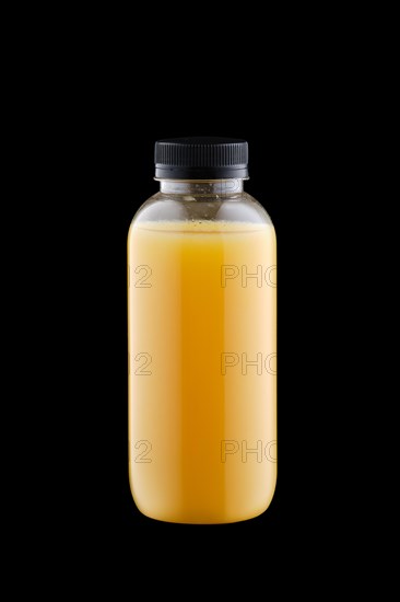 Plastic bottle with orange juice isolated on black