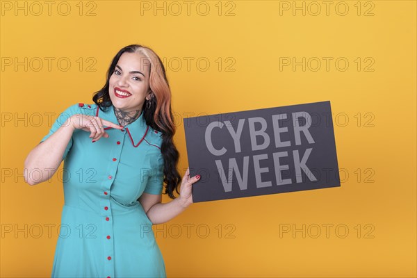 Beautiful woman holding and pointing a Cyber Week sign. Commercial concept. Commerce