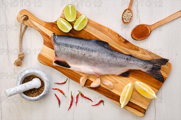 Top view of raw fresh headless pink salmon on wooden cutting board