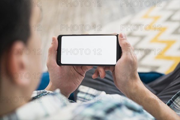 Man looking smartphone settee