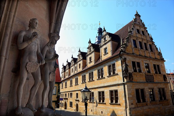 The figures of Adam and Eve on the main portal of the church of St. Moritz and the building of the Casimirianum grammar school