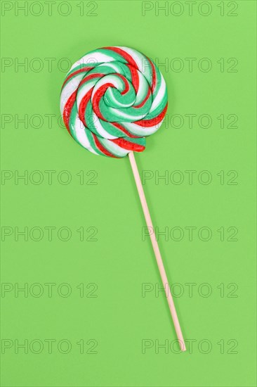 Lollipop with Christmas colors on green background
