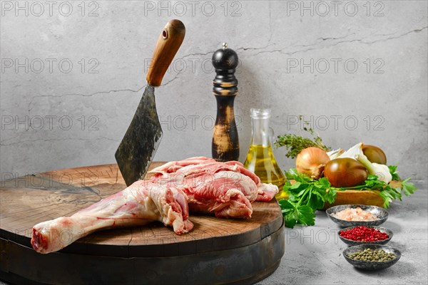 Raw lamb shoulder half cut on wooden slab