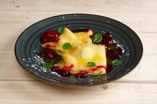 Pancakes with cherry jam decorated with mint leaves