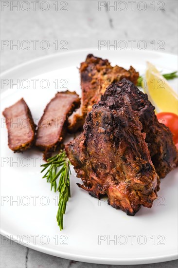 Closeup view of lamb saddle marinated in mustard baked in oven on narble table